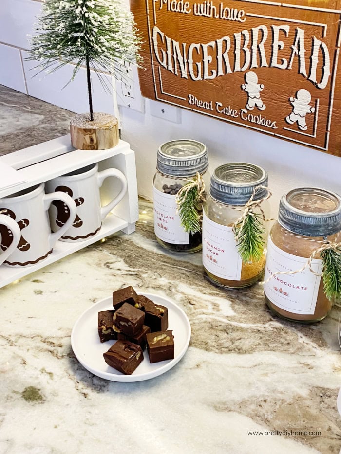 Small Christmas coffee and hot cocoa bar with gingerbread mugs, vintage jars, and chocolate toppings.