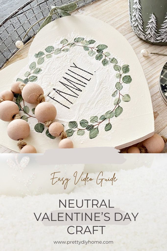 An easy to make neutral Valentine's Day wood craft in soft whites, creams and greens.  The Valentine shaped DIY wood riser is sitting on a tray with natural wood beads, a green candle in a jar and green coffee coasters.