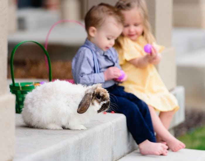 Two little kids sitting on a porch enjoying Easter eggs