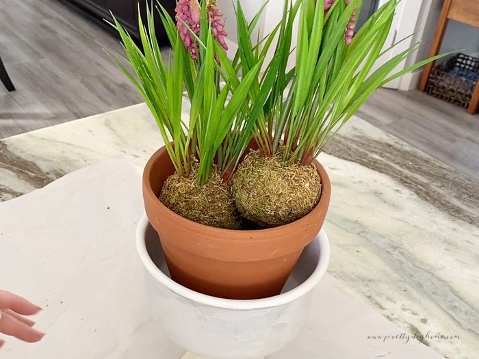 Two faux Spring flower bubls in a beautiful DIY planter for Spring.