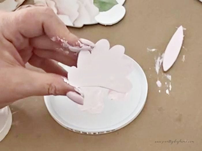 Painting the wooden tail and ear of a Dollar Tree wooden rabbit cutout pink.