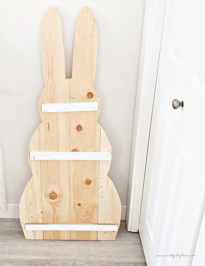 The back side of a large wooden bunny showing the placement of the cross pieces to hold the lumber together securely.