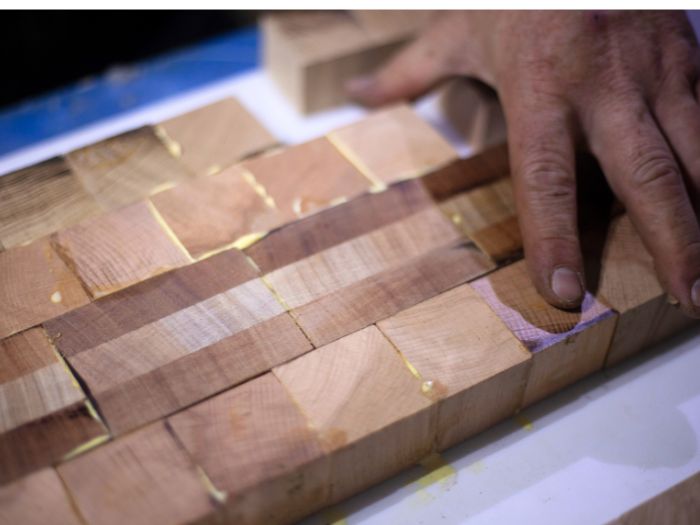 Pieces of various hardwood being glued together.