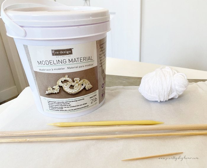 The supplies needed to make a set of air dry beads, and a home decor string of beads.