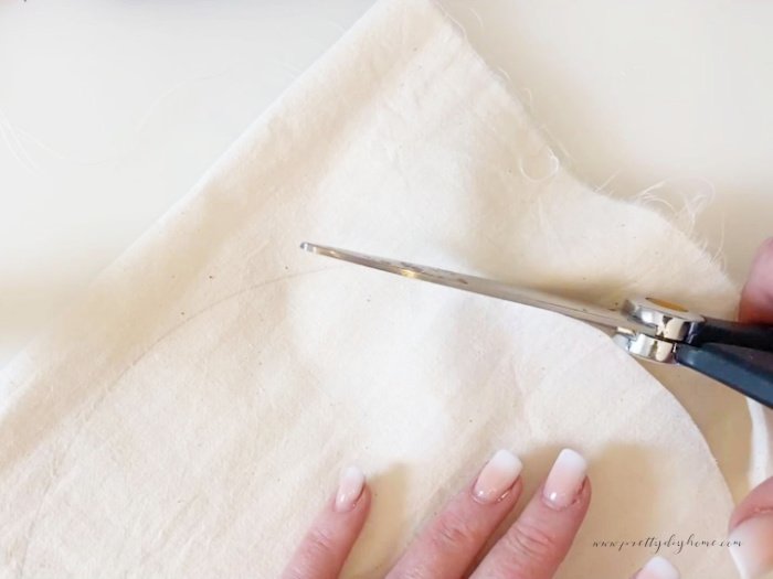 Cutting out a pincushion circle with scissors.