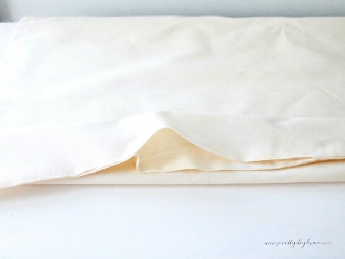 A DIY pillow insert with 3 seams sewn, and the last seam showing an opening to add stuffing.