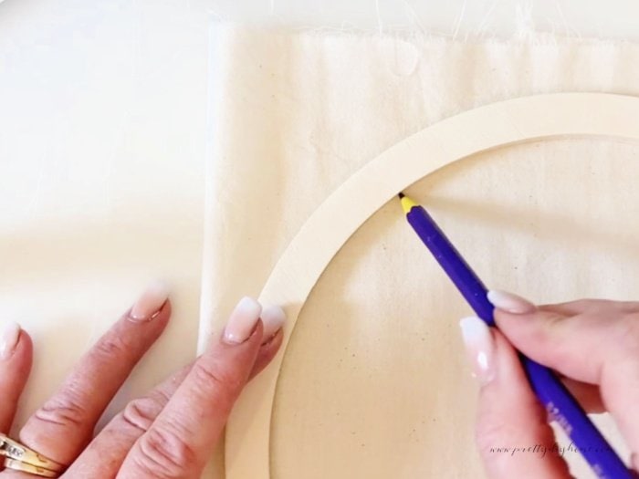 Drawing a circle onto fabric with a pencil before cutting it out while make a quick pin cushion project.