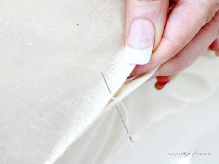 Hand sewing a seam opening for stuffing on a DIY pillow insert.  Holding the seams together so they align perfectly.