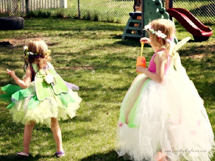 Two preschool aged little girls playing in no sew tutus for kids. One tutu is long and the other one is short.