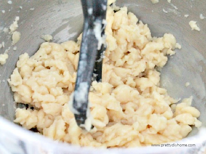 Choux pastry being mixed in a bowl with eggs.