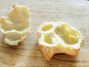 A cream puff shell with the top cut off for adding a berry filling.