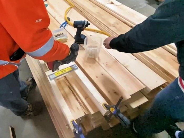 Placing, leveling and attaching the horizontal slats on a DIY garden obelisk project.