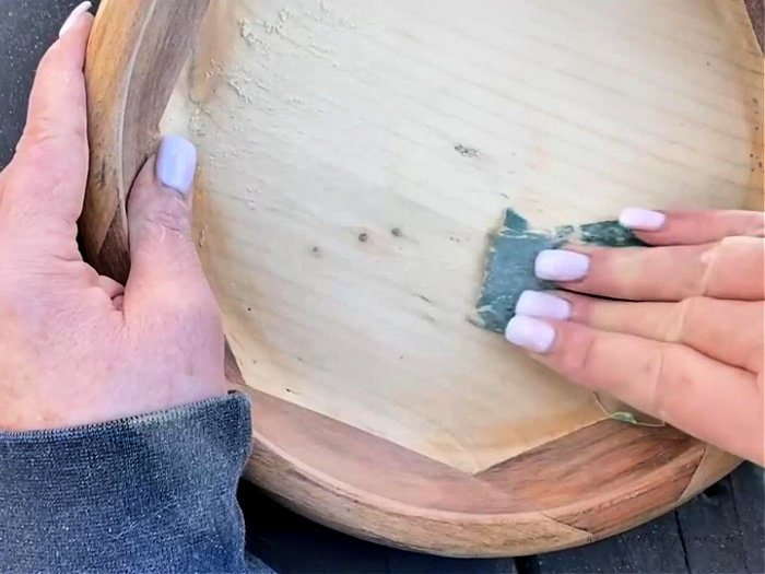 Sanding a vintage wooden thrift store bowl by hand using 120 grit sandpaper.