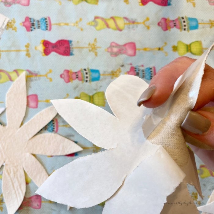 Removing the backing from heat and bond interfacing from the back of a fabric flower petal