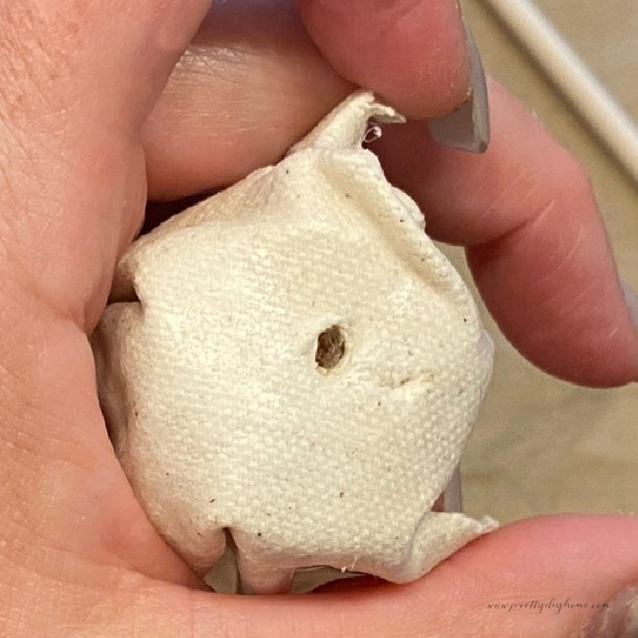 A hole in the bottom of a fabric flower for inserting a stem.