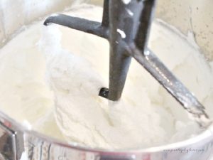 Mixing the ingredients for a pumpkin cookie recipe in a stand mixer with a paddle attachment.