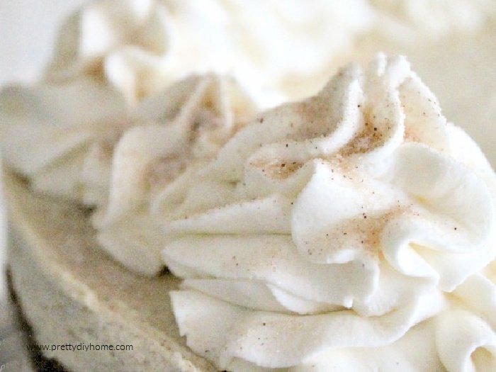 A closeup of large swirls of beautiul whipped cream with cinnamon sugar dusting on top.