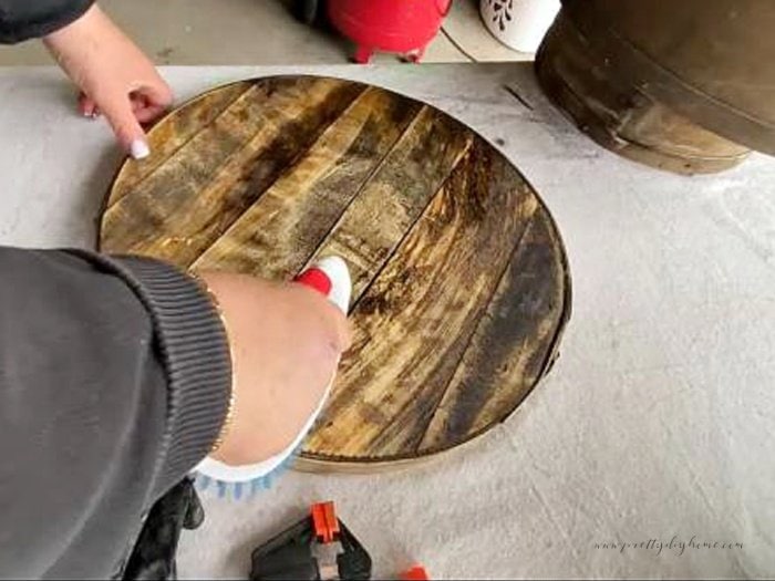 A vintage wood cheesebox being cleaned with a scrub brush and Murphy's Oil soap.