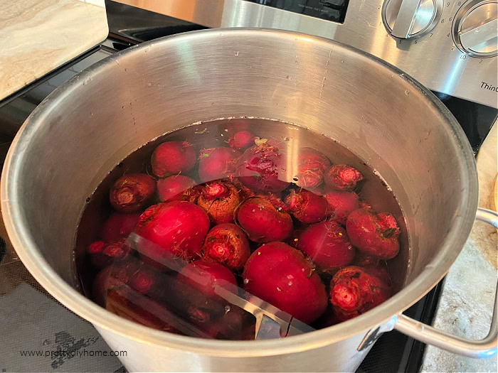 A very large cooking pot filled with fresh beets covered with water before boiling.