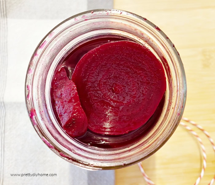 A jar of spiced pickled beets, its open and you can see the sliced beets inside.