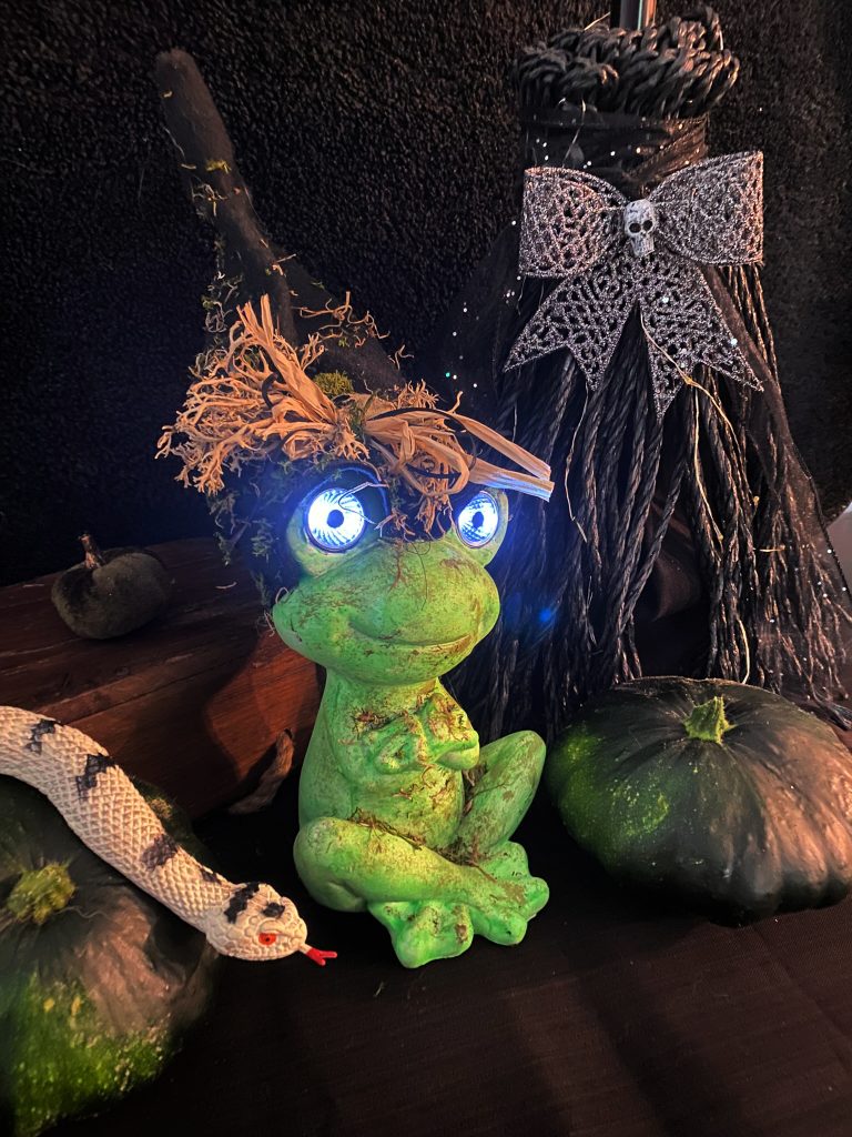 A DIY Halloween decoration of a frog with large light up eyes.  Its a great light source for lighting up your Halloween front porch at night.