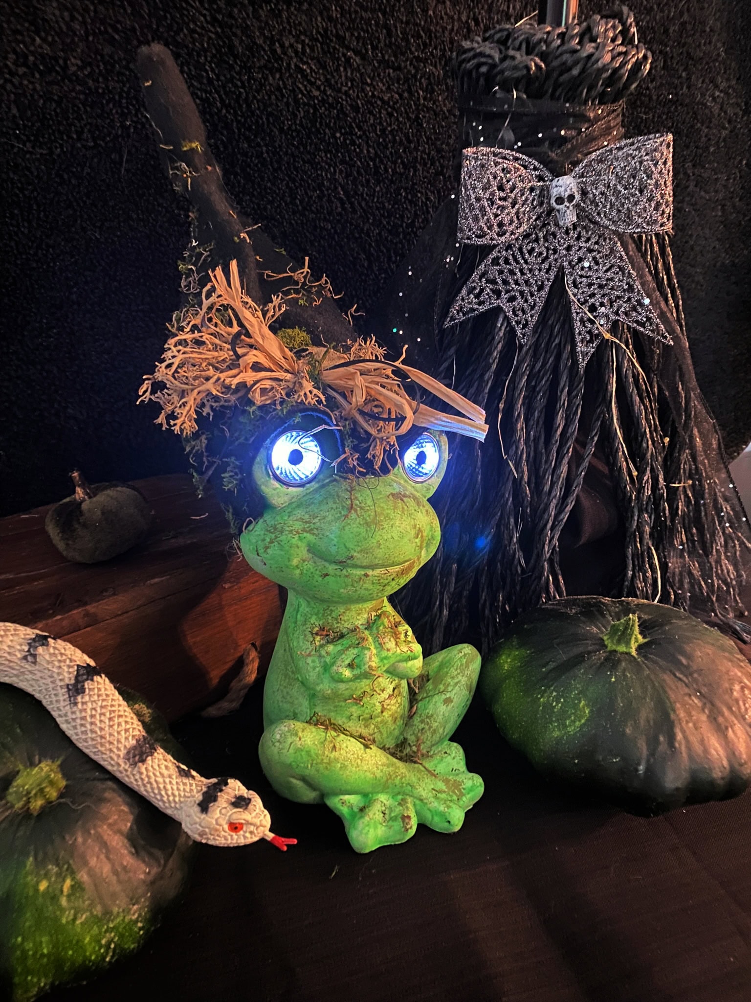 A DIY Halloween decoration of a frog with large light up eyes. Its a great light source for lighting up your Halloween front porch at night.