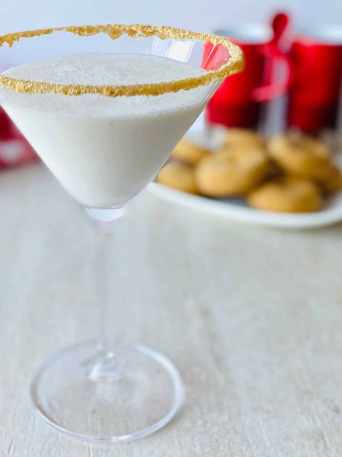 A homemade gingerbread martini cocktail served in a martini glass thats been rimmed with gingerbread cookie crust.