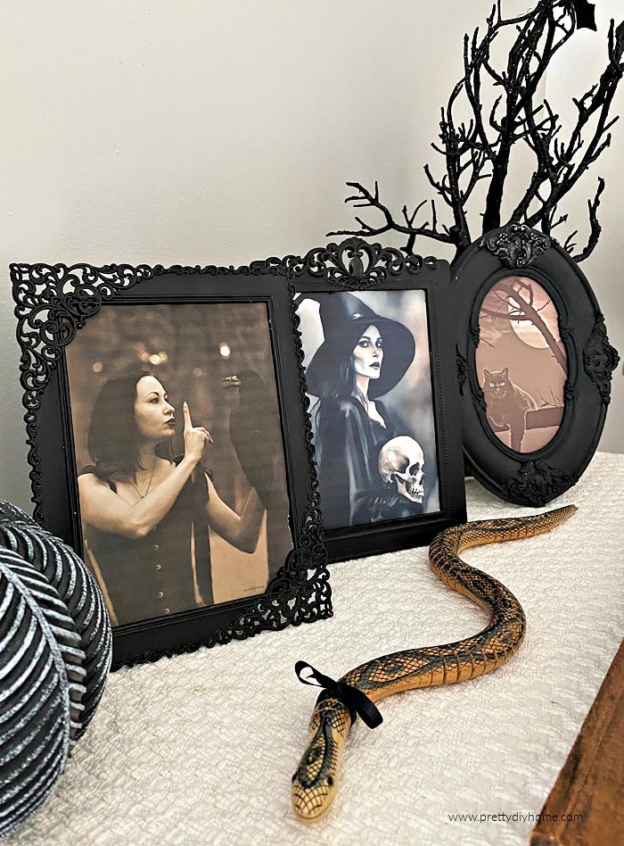 three Halloween picture frames painted black with free printable witch themed images. The three frames are surrounded with sparkling tree, a sparkling pumpkin and a wood snake.