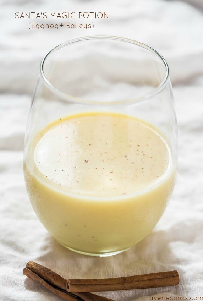 A Christmas drink called Santa's Magic Potion in a clear glass. The drink is made of eggnog mixed with Bailey's irish cream. The glass is sitting on a granite counter.