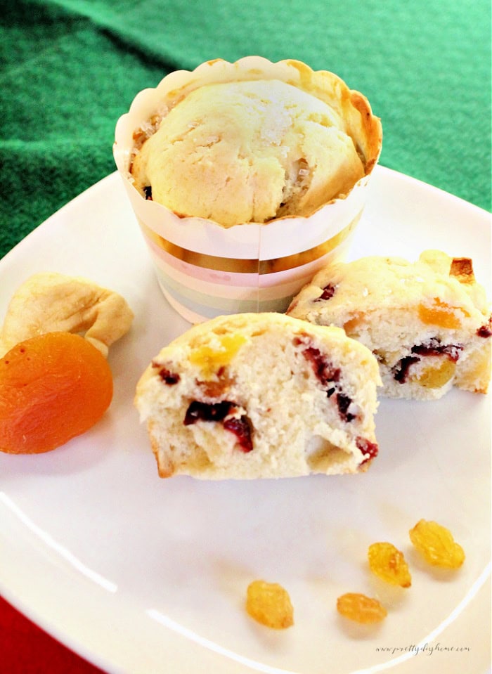 Panettone Muffins for Christmas breakfast served on a white plate with a Christmas green tablecloth background.