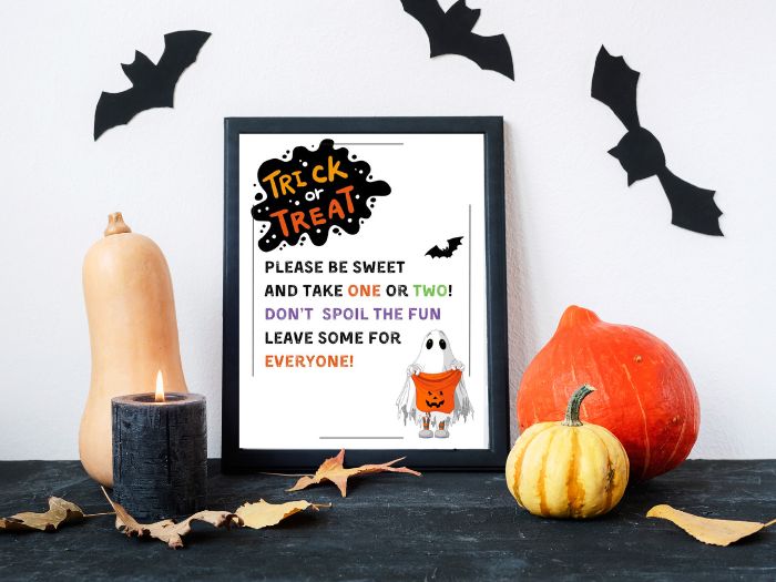 A happy ghost with an empty bag of candy, free printable Halloween candy sign. The sign says Trick or Treat please be sweet and take one or two? Don't spoil the fun leave some for everyone!