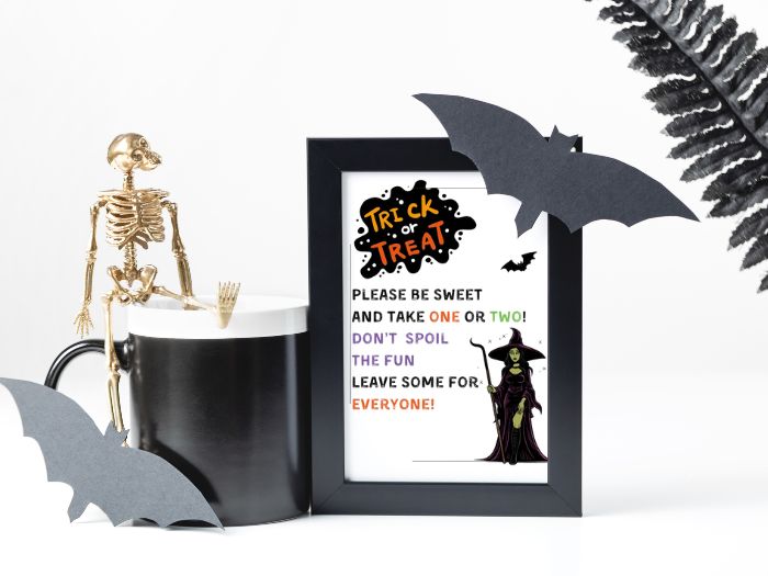 A witch themed free printable Halloween candy sign with a trick or treat blotch in the top corner, a small bat, and a large with with a staff in the bottom corner. The signs says "please be sweet and take one or two! Don't Spoil the fun leave some for everyone!