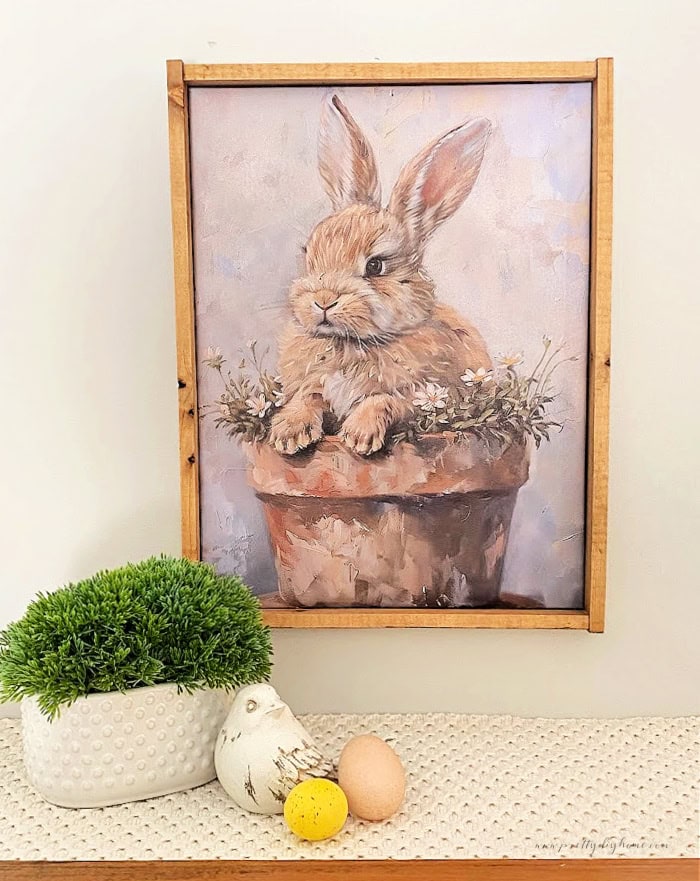 An adorable easter bunny art print, thats been framed with a diy wood picture frame and then hung up as simple Easter decor.