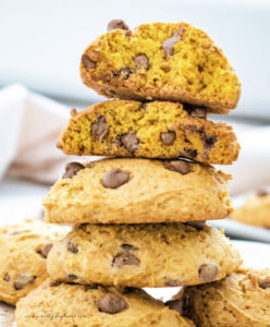 A large stack of golden brown pumpkin cookies. These pumpkin cookies can have chocolate chips or white chocolate chips added.