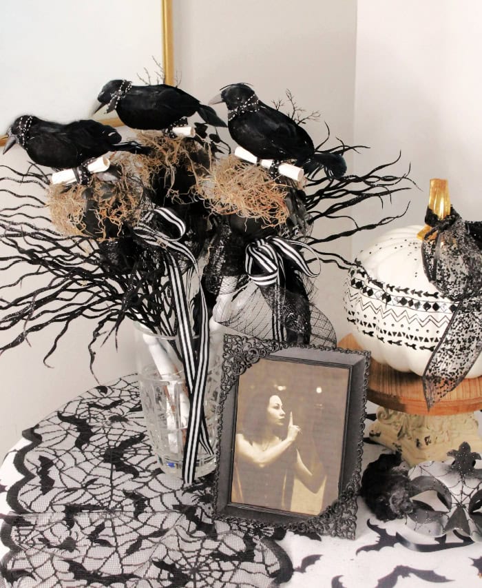 Three DIY Halloween with wands you can use for Halloween decorations, party favors, or costume prop. They are in neutral colors, black, white and gold, and feature a small black crow on top of a spindle.