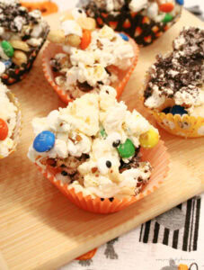 Rows of homemade Halloween popcorn being served in single size servings on a tray.