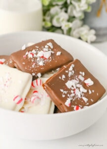 A cozy Christmas snack of chocolate covered graham crackers, styled with a glass of milk and festive greenery.