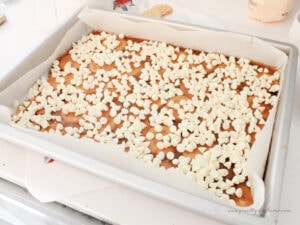 White chocolate chips melting on warm toffee layer