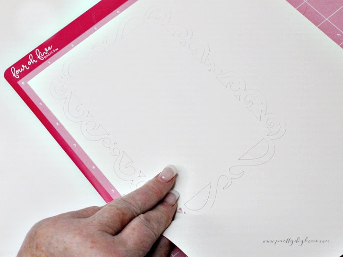 Full cardstock sheet with the lace background cut on the Cricut mat before weeding.