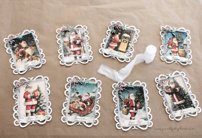 Glittered Santa banner panels laid out on brown paper to dry before assembling the banner.