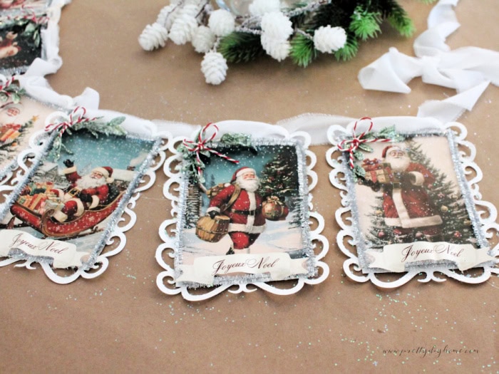 Threading soft white ribbon through the lace background to string the vintage Santa banner panels.