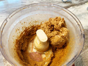 Mixing crushed gingersnaps, cream cheese, and spices for homemade gingerbread truffles.