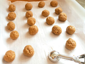 Rolling gingerbread truffle dough into balls with a small cookie scoop.