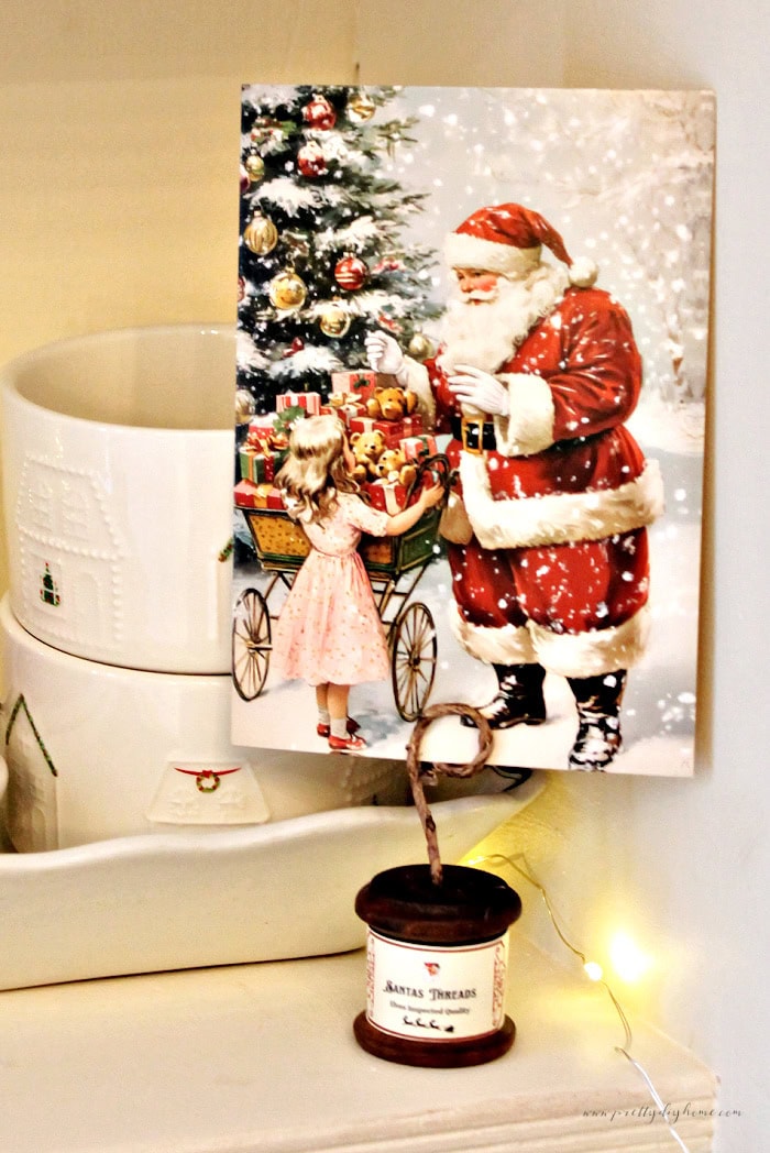Finished wooden spool postcard holder with a santa postcard and vintage Christmas display.