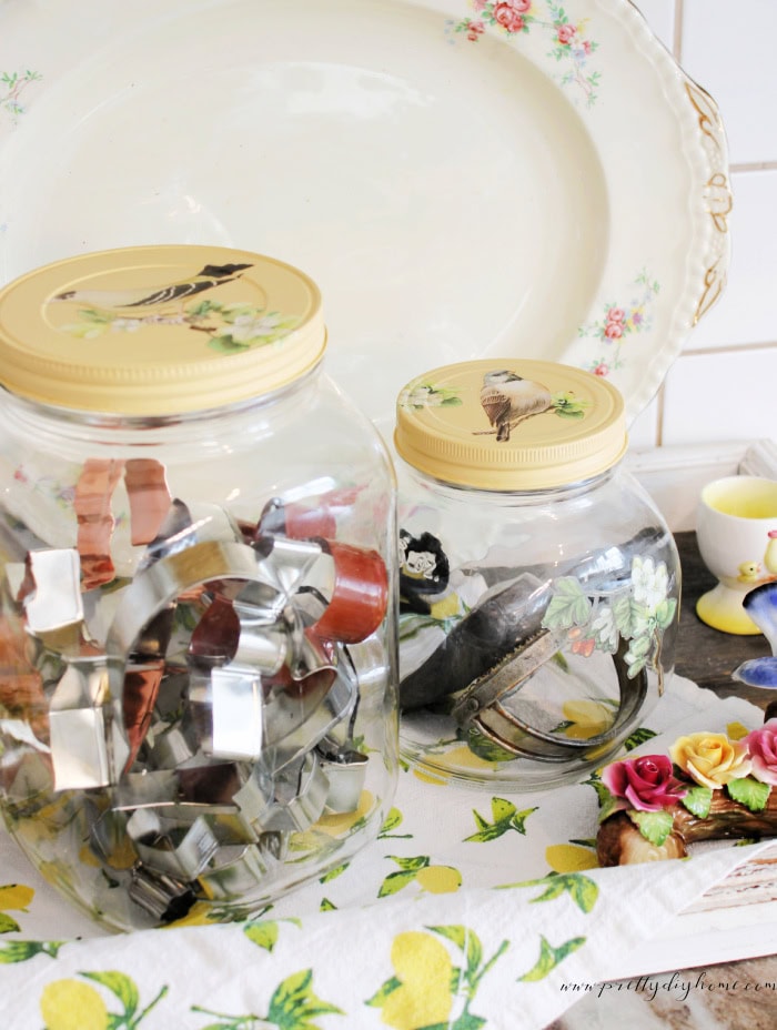 Vintage glass jars used for storing baking tools in a cottage style kitchen.