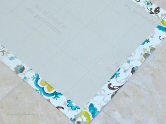 A DIY pet feeding mat with fabric edges folded and secured around the linoleum base.