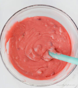 A strawberry slab cake batter mixed in a bowl with fresh strawberries visible.