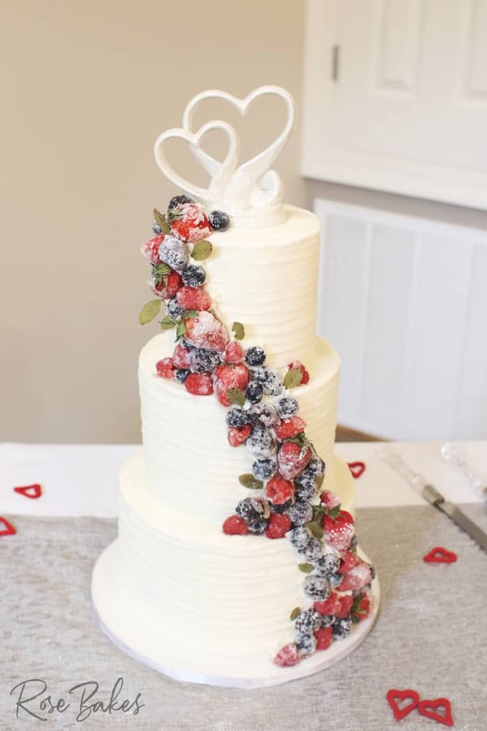 Berry Chantilly cake with cascading strawberries and blueberries down the front.