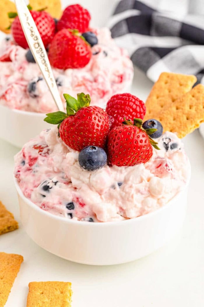 Berry cheesecake fluff topped with fresh strawberries, raspberries, and blueberries