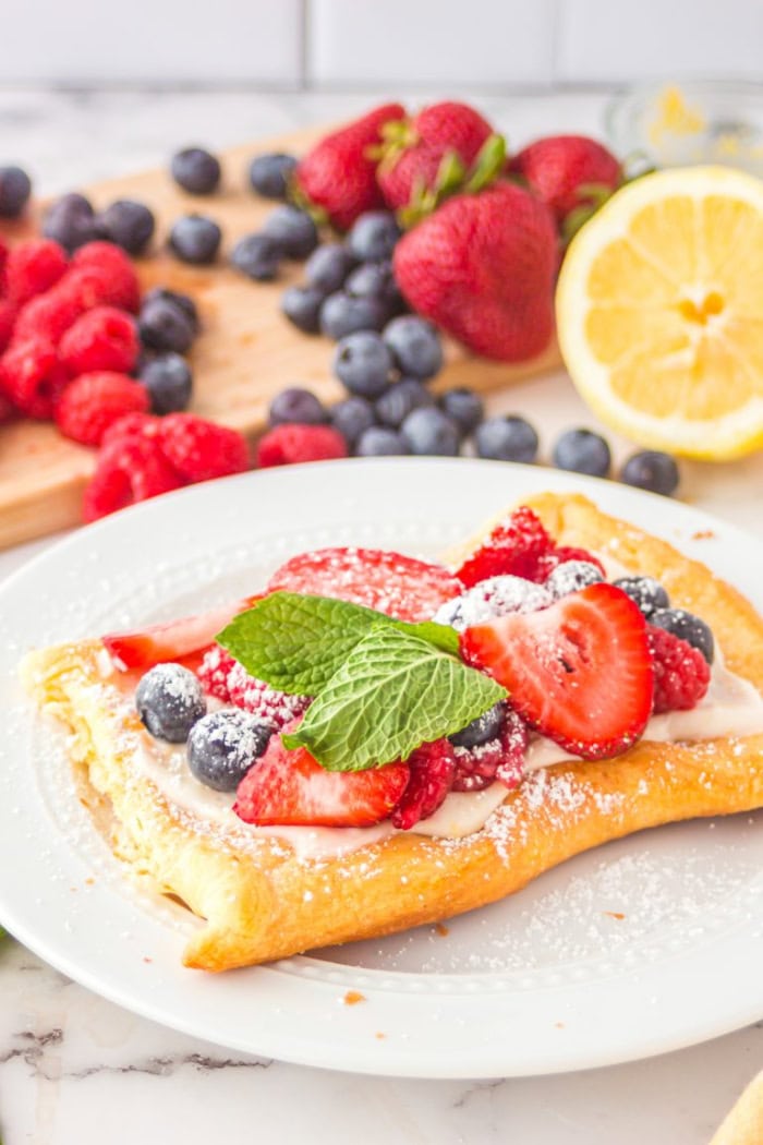 Berry tart made with crescent dough and topped with fresh strawberries, blueberries, and raspberries.